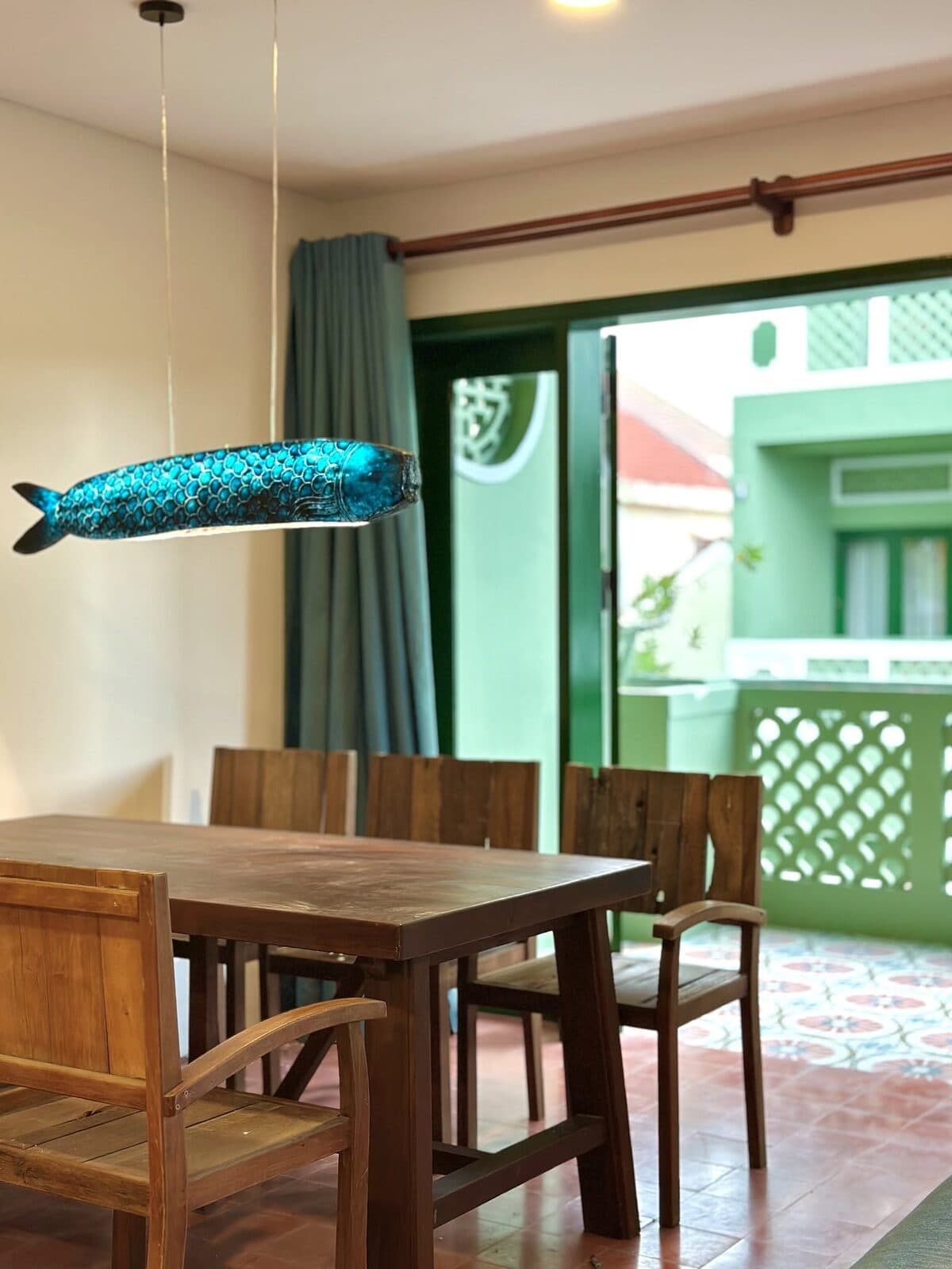 A dining table beside a green sliding door inside an apartment at the collective
