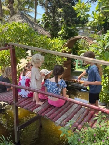 Children playing music together on a covered bridge