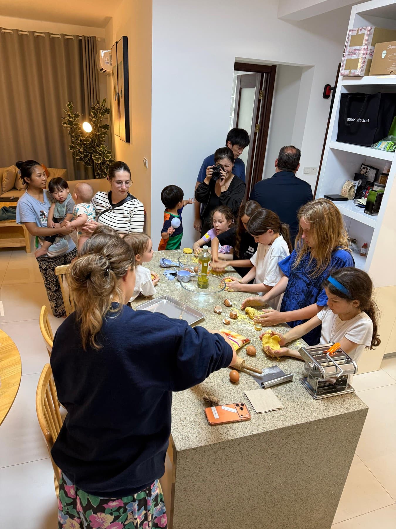 Children and parents making fresh pasta together at a Network School family workshop