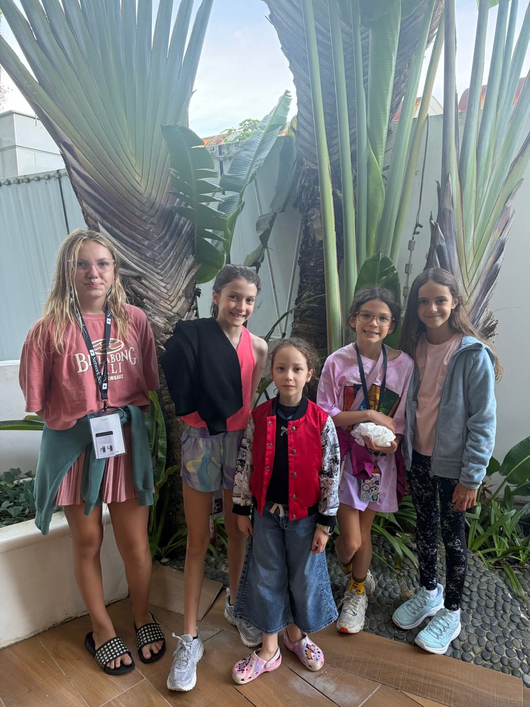 Five young worldschoolers with their event lanyards