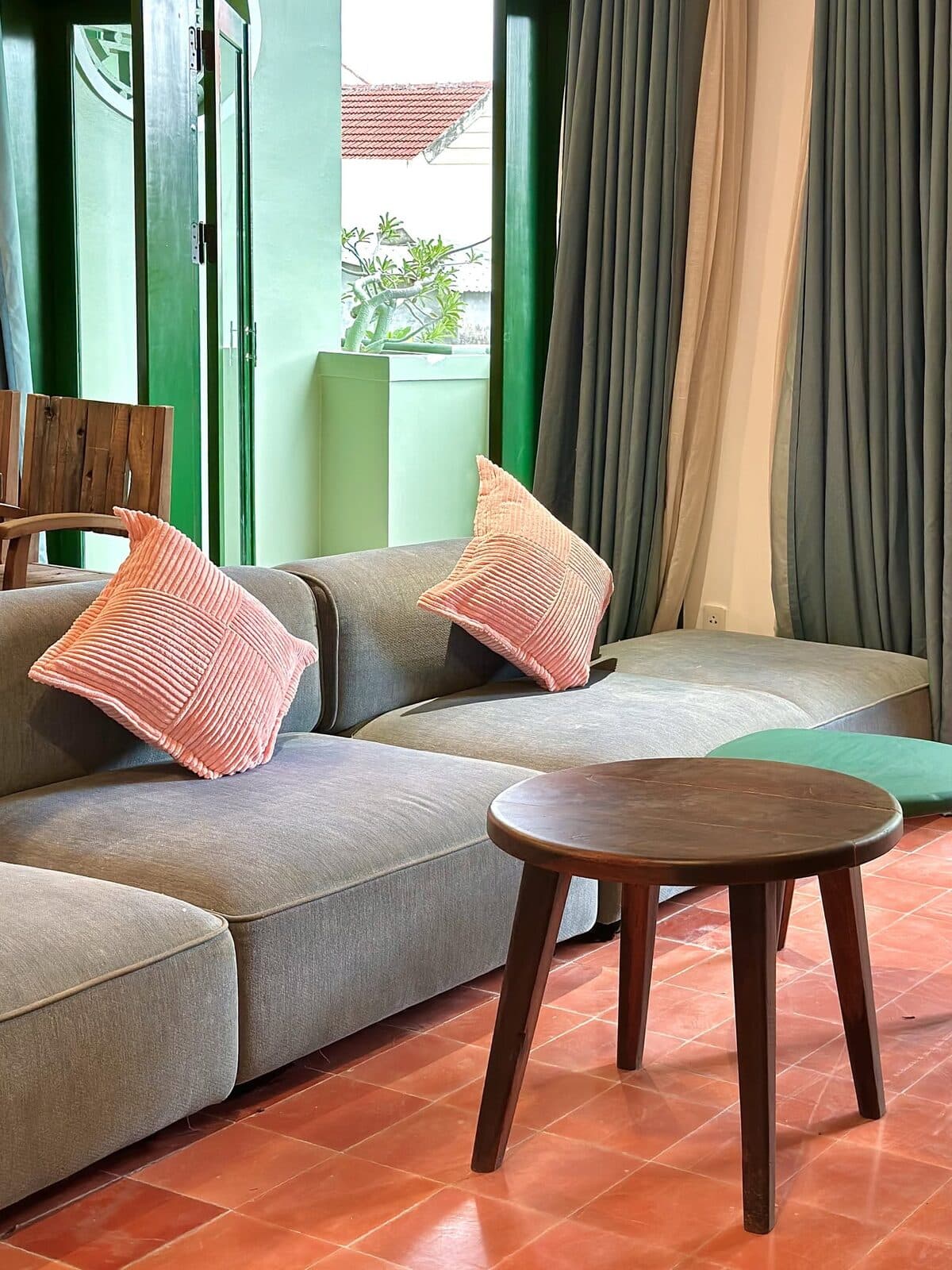 A bright apartment living room with a sofa, coffee table, and a balcony beyond
