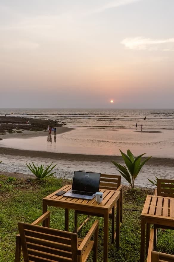 Working from a beach-facing table over Mandrem Beach at sunset