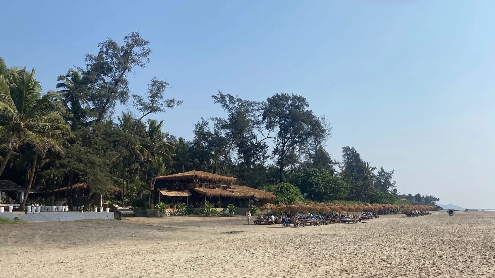 A quiet stretch of Mandrem Beach with a palm-roofed shack